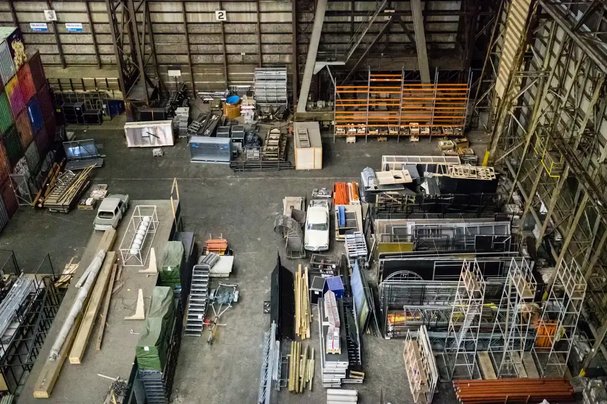 Vista do alto de um galpão industrial com estruturas, equipamentos e materiais armazenados