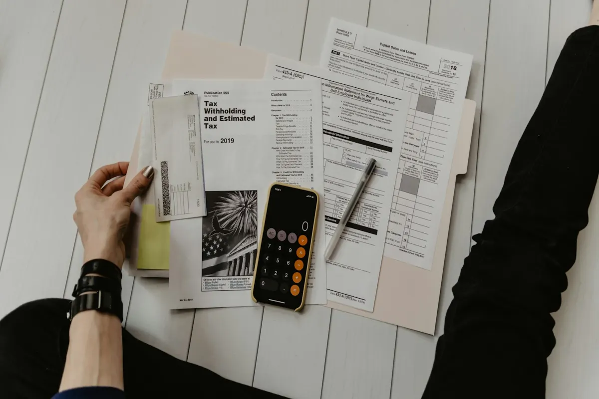 Mesa com documentos fiscais, calculadora e anotações